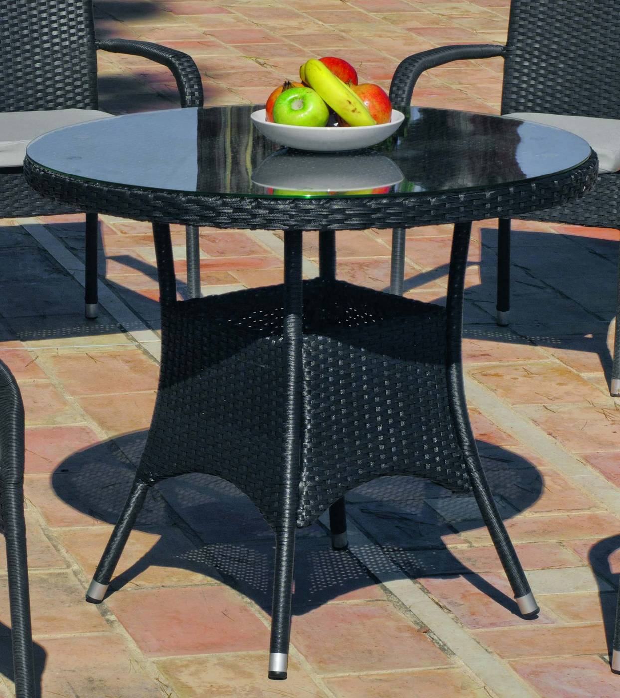 Mesa redonda de comedor para jardín o terraza. Fabricada con médula sintética. Tada de cristal templado.