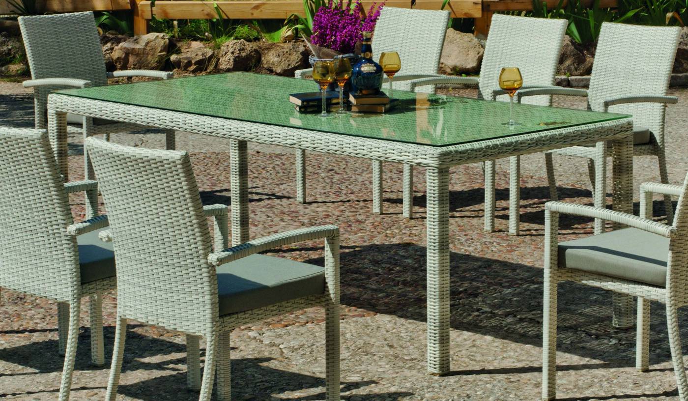 Mesa rectangular de comedor  para jardín o terraza. Estructura de aluminio recubierta de médula sintética, con tablero de cristal templado.