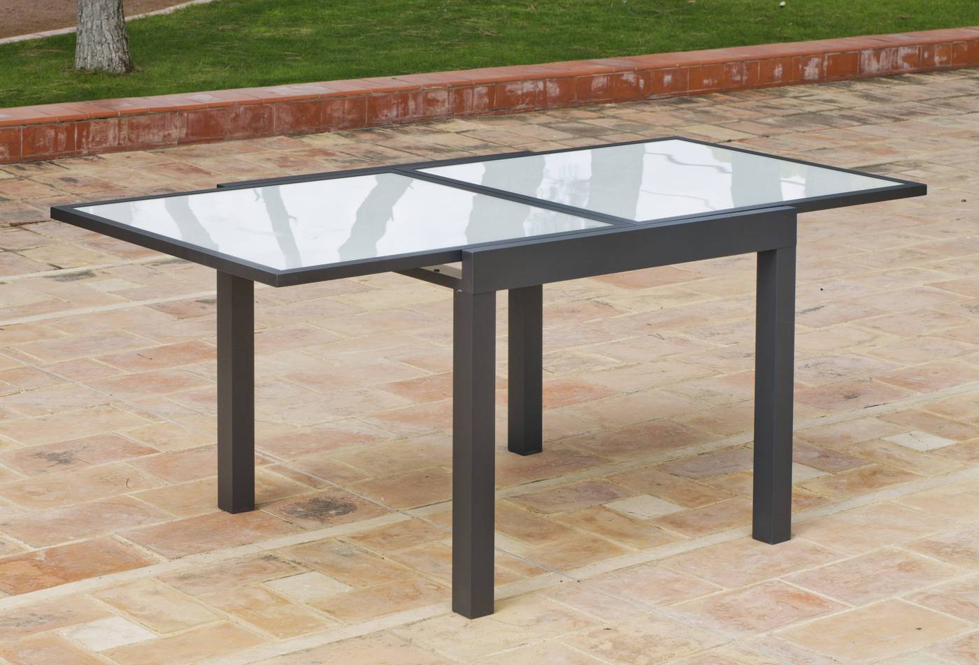 Mesa extensible 90-180 cm, de aluminio color antracita con tablero de cristal templado.