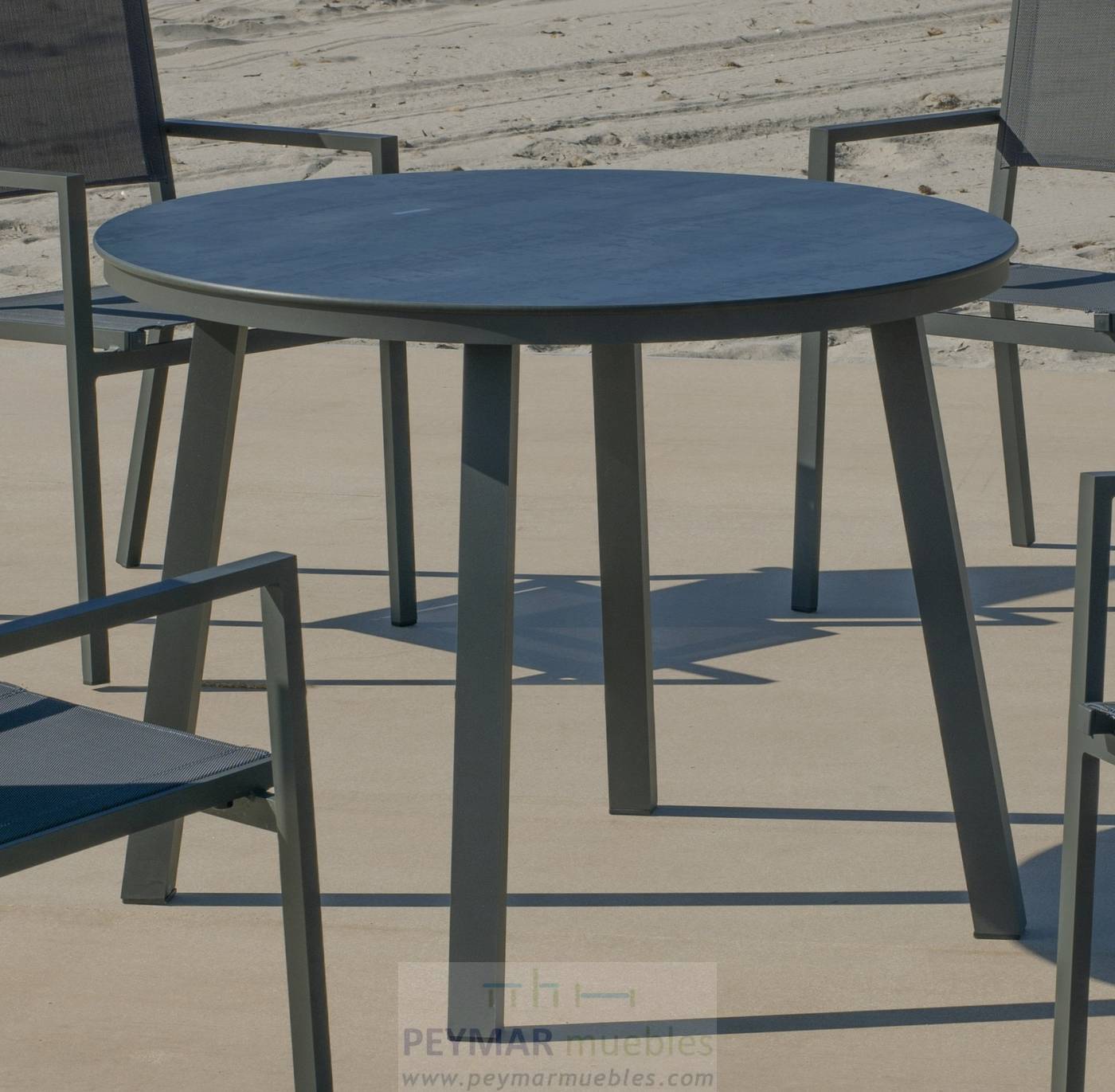 Mesa redonda de aluminio, con patas cuadradas y tablero HPL de 100 cm. Disponible en color blanco, antracita o champagne.