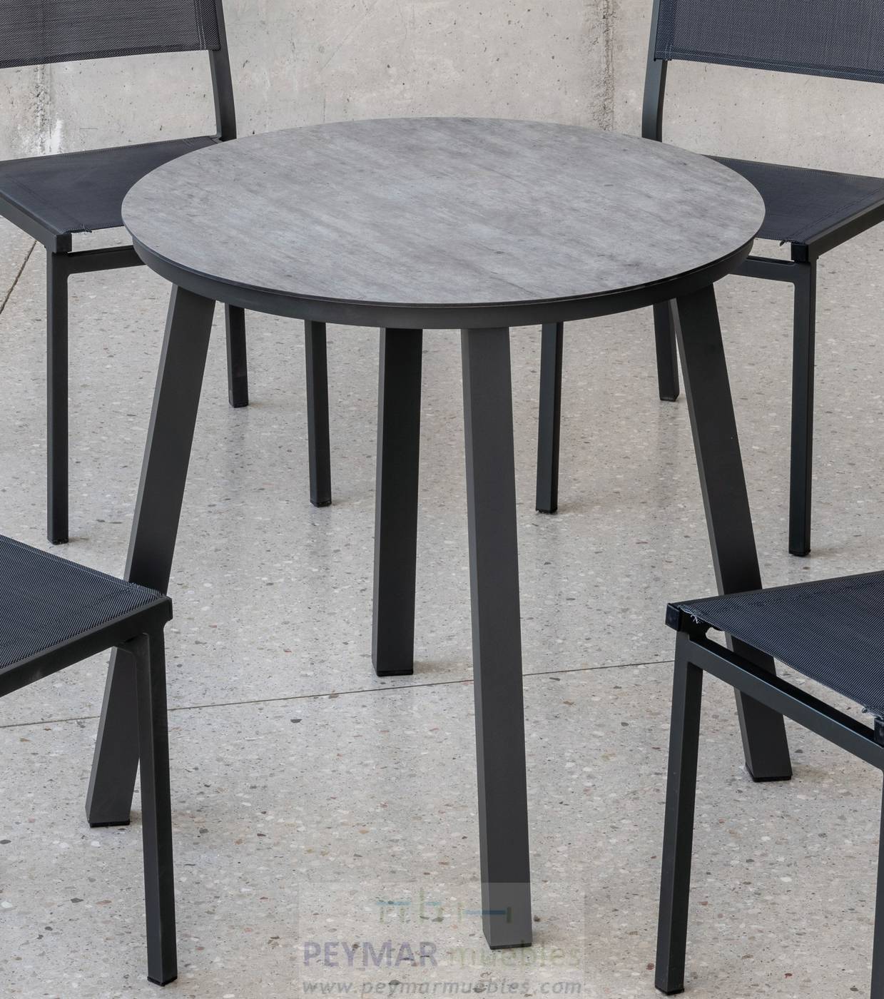 Mesa redonda de aluminio, con patas cuadradas y tablero HPL de 80 cm. Disponible en color blanco, antracita o champagne.