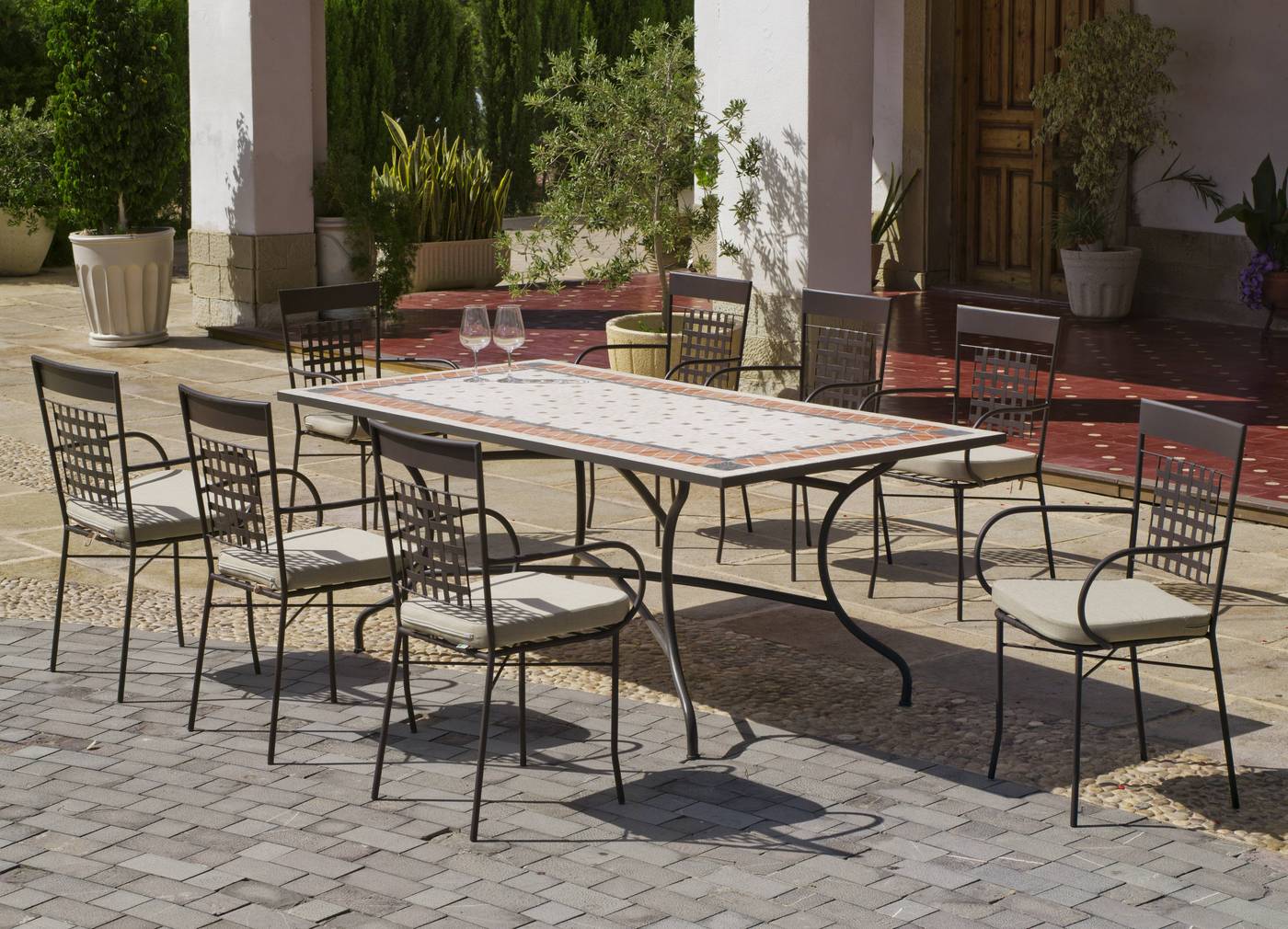 Conjunto para terraza o jardín de forja color bronce: 1 mesa con  tablero mosaico extra resistente + 8 sillones con cojín.