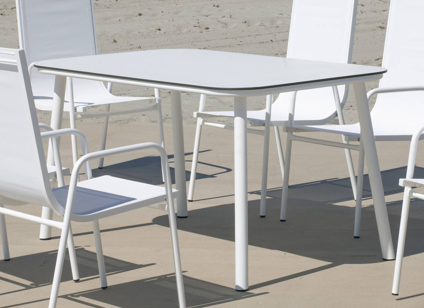 Mesa rectangular de aluminio, con pata circular y tablero HPL de 150 cm. de esquinas redondenadas. Colores: blanco o antracita.